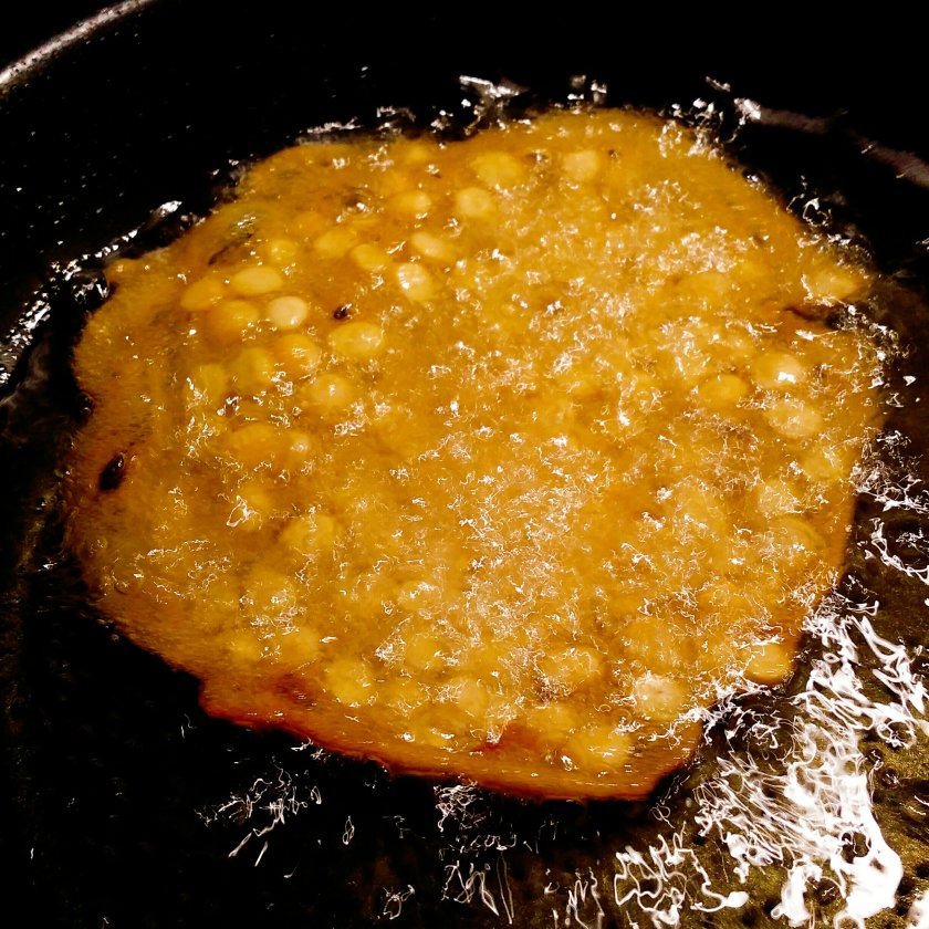 Split baby chickpea crackers frying in shallow oil